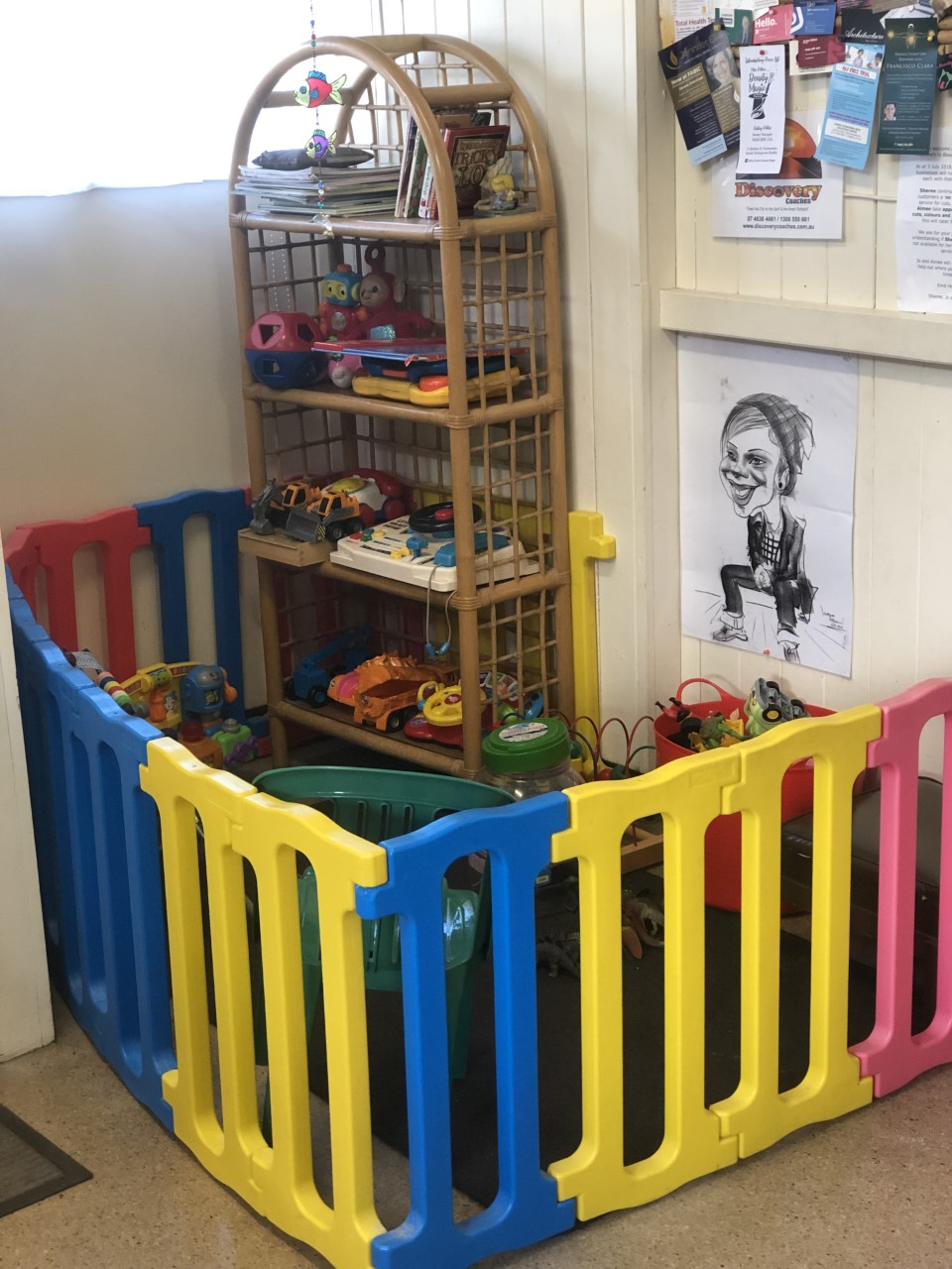 A colourful kids' play pen with toys and books inside the salon